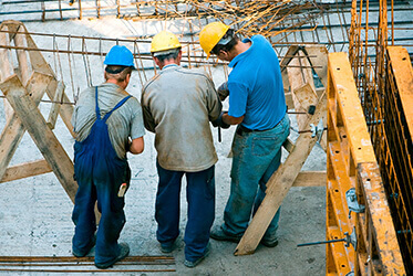 workers in hard hats working on a building site